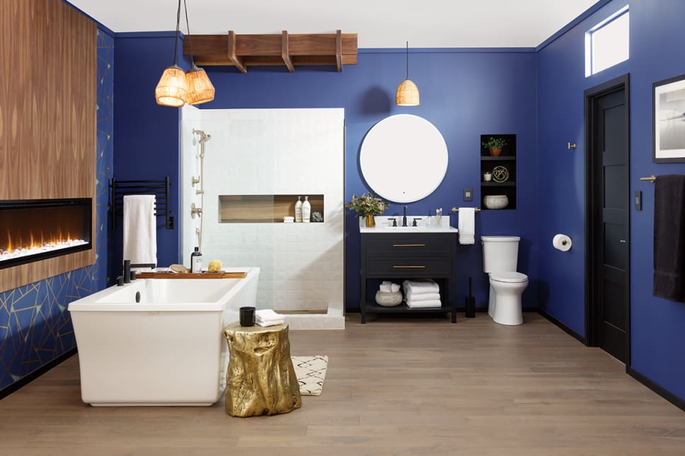 Bathroom with periwinkle walls, freestanding tub, black vanity, fireplace