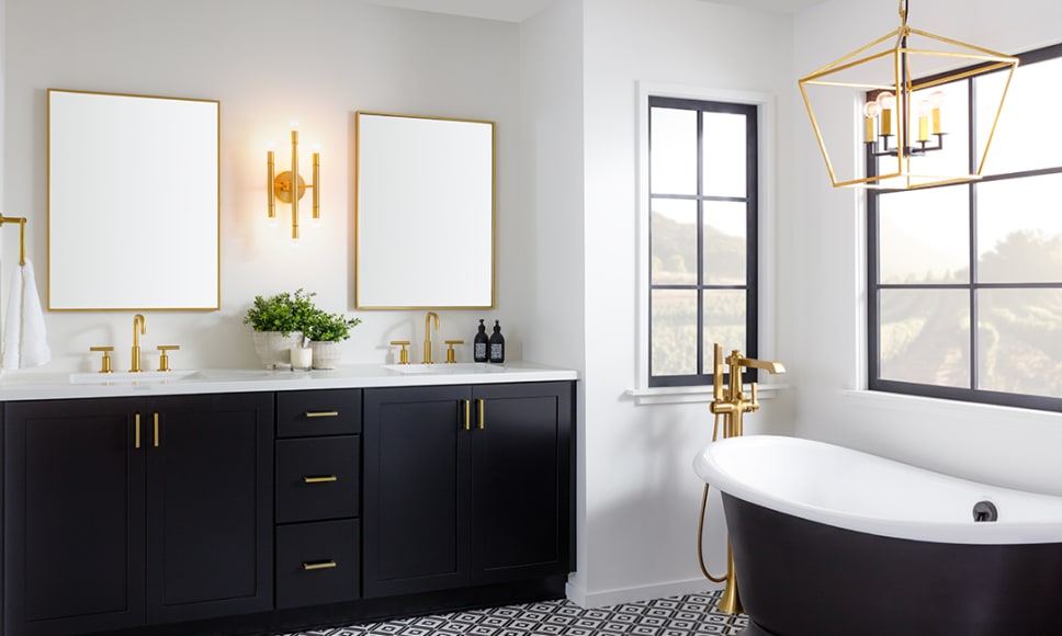 Bright bathroom with gold lighting, fixtures, and cabinet hardware