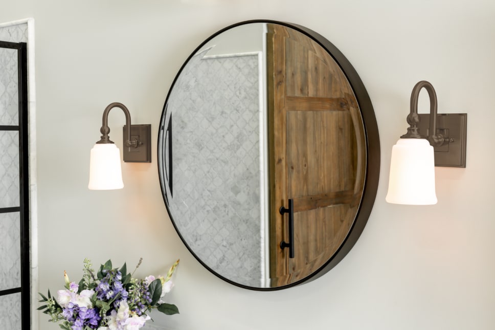 Two bathroom wall sconces with a mirror in between