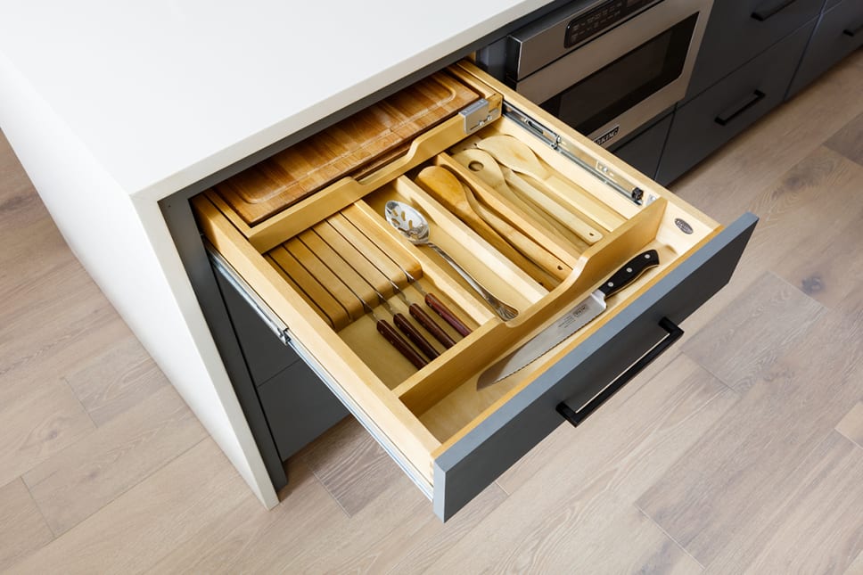 Drawer with insert organizers, cooking utensils and cutlery neatly placed.