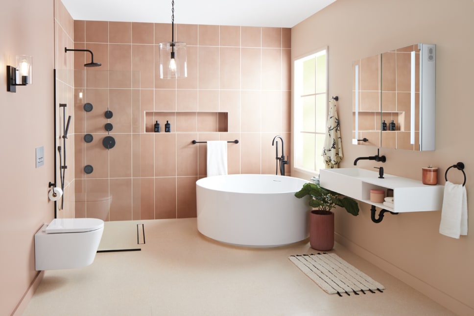 Wet room bathroom with matte black finishes and pink tile.